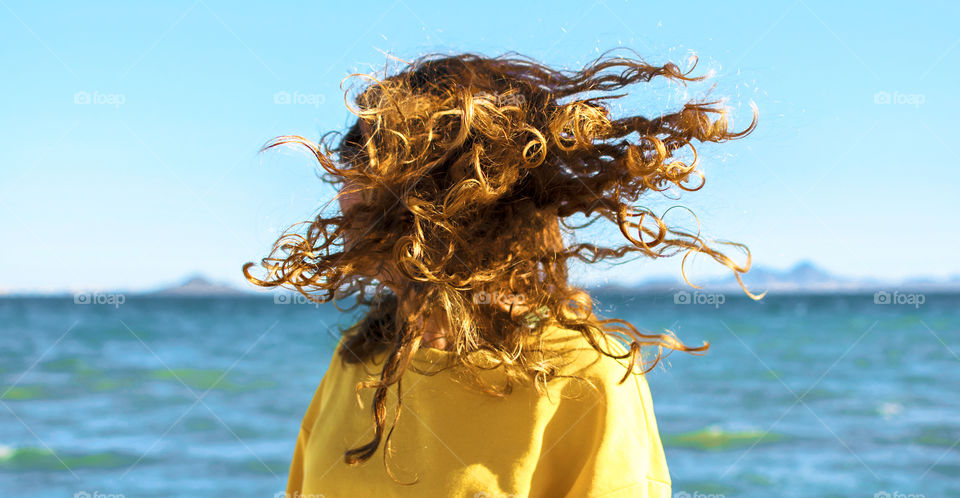 Curly blonde girl at the beach