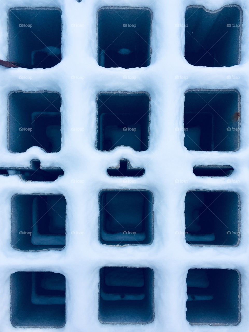 Snow-covered edges of cinder block from above