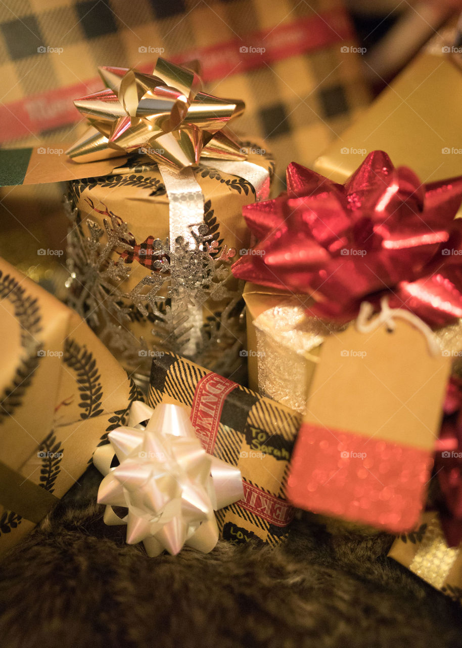 Rustically wrapped Christmas gifts hiding under the tree. 