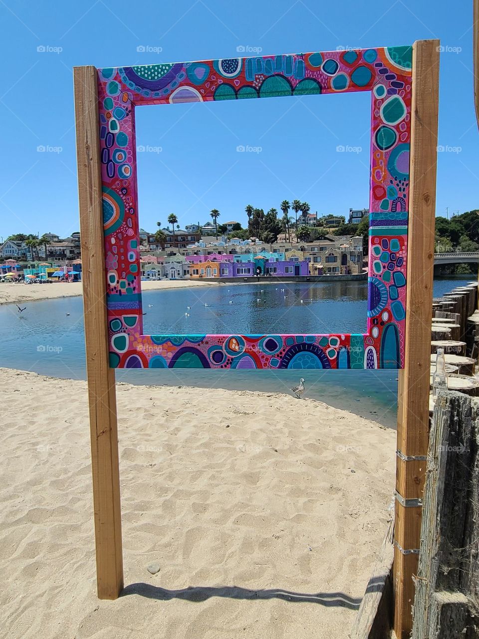 Colorful frame built on a beach in Capitola California with a view of the Venetian condominiums and the soquel river 