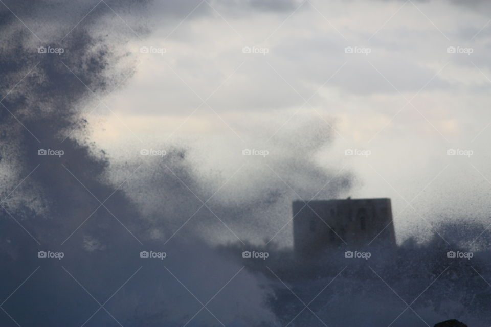 Stormy waves next to the coast scatter into the air. Salento, Italy