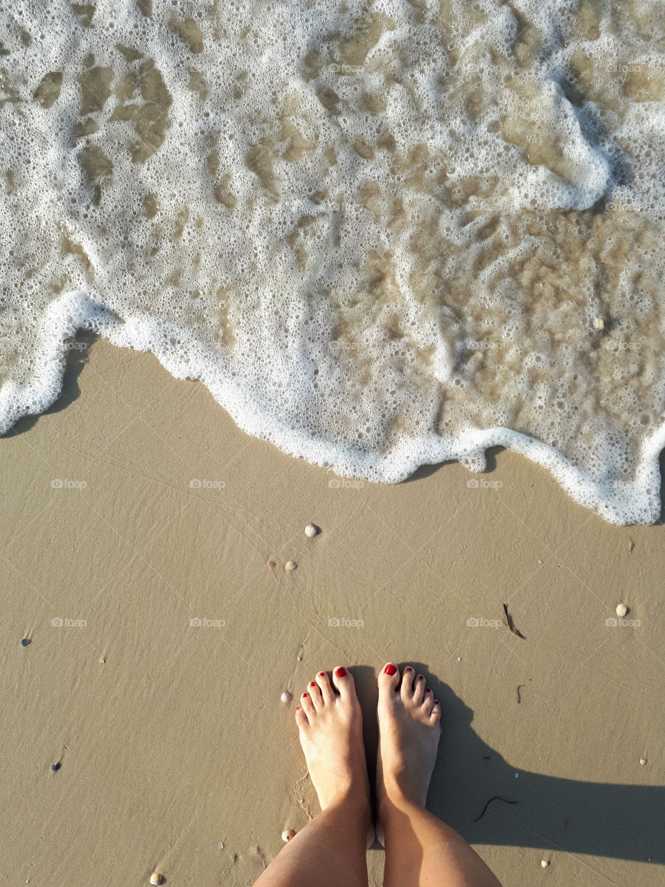 Barefeet near sea wave