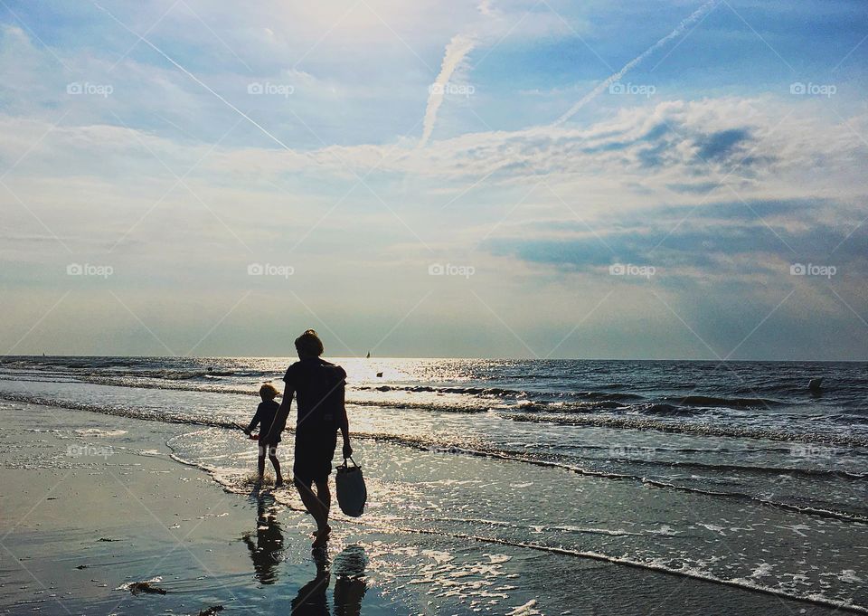Father and child walking on the beach
