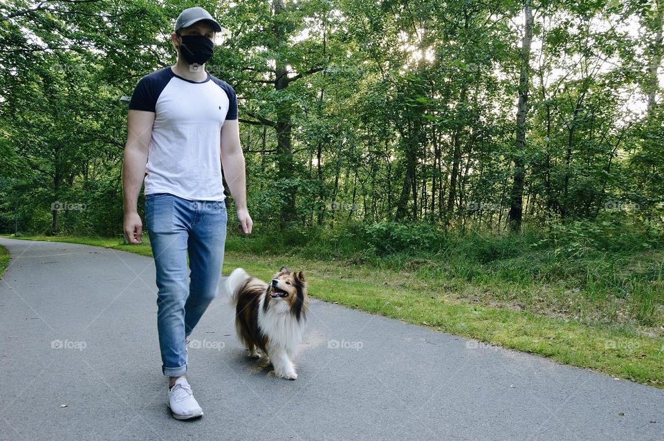 Photo of a young man hiking with dog