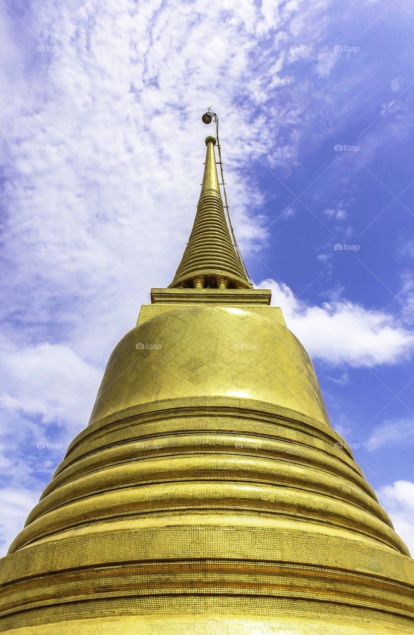 Golden pagoda in temple Thailand with blue sky background