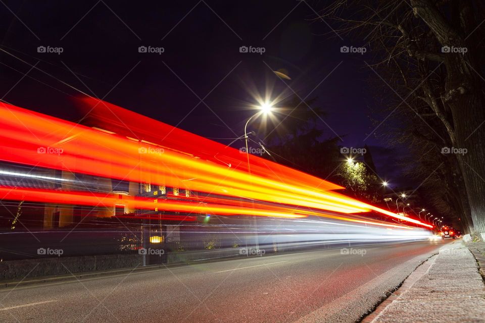 streaks of car lights along a tree-lined avenue in the middle of the night, Long exposure