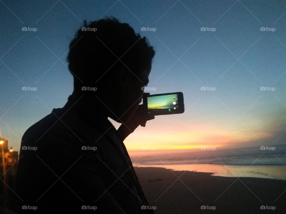 a boy catches videos by using its smartphone .