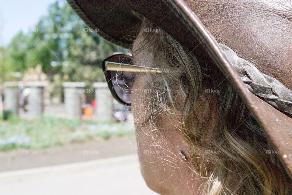 Middle aged blonde woman in leather cowboy hat side view profile