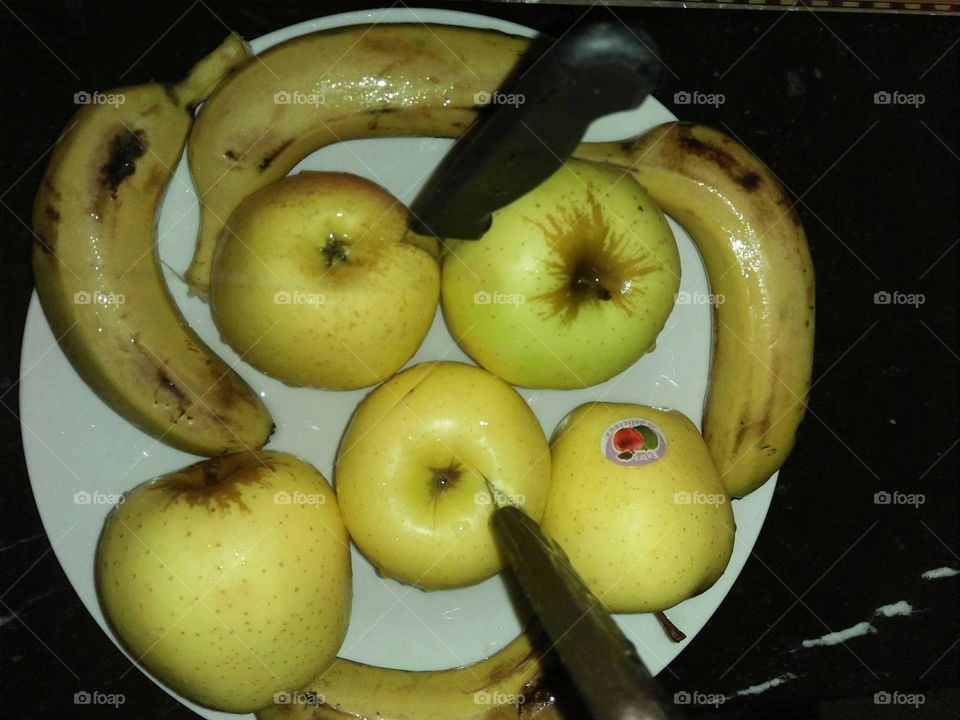 Plate full of apples and bananas.