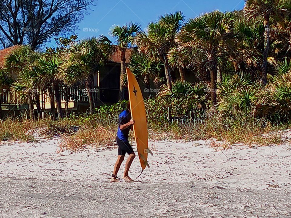 Young man with a surf board staying in shape.