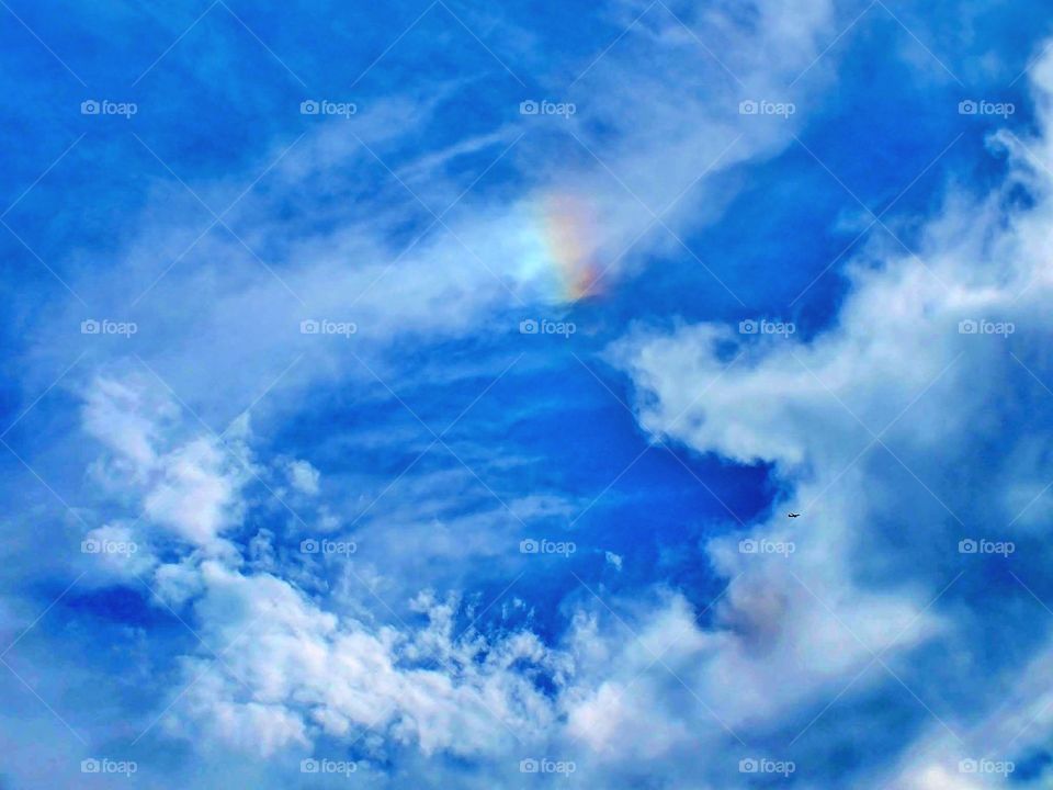 Pretty blue sky. Small rain now and airplane 