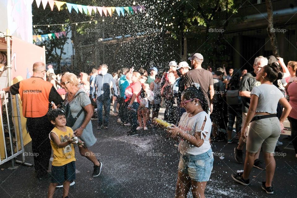 Buenos-Aires, 22.02.2022: Participants of carnival in Buenos-Aires shoot foam on the street