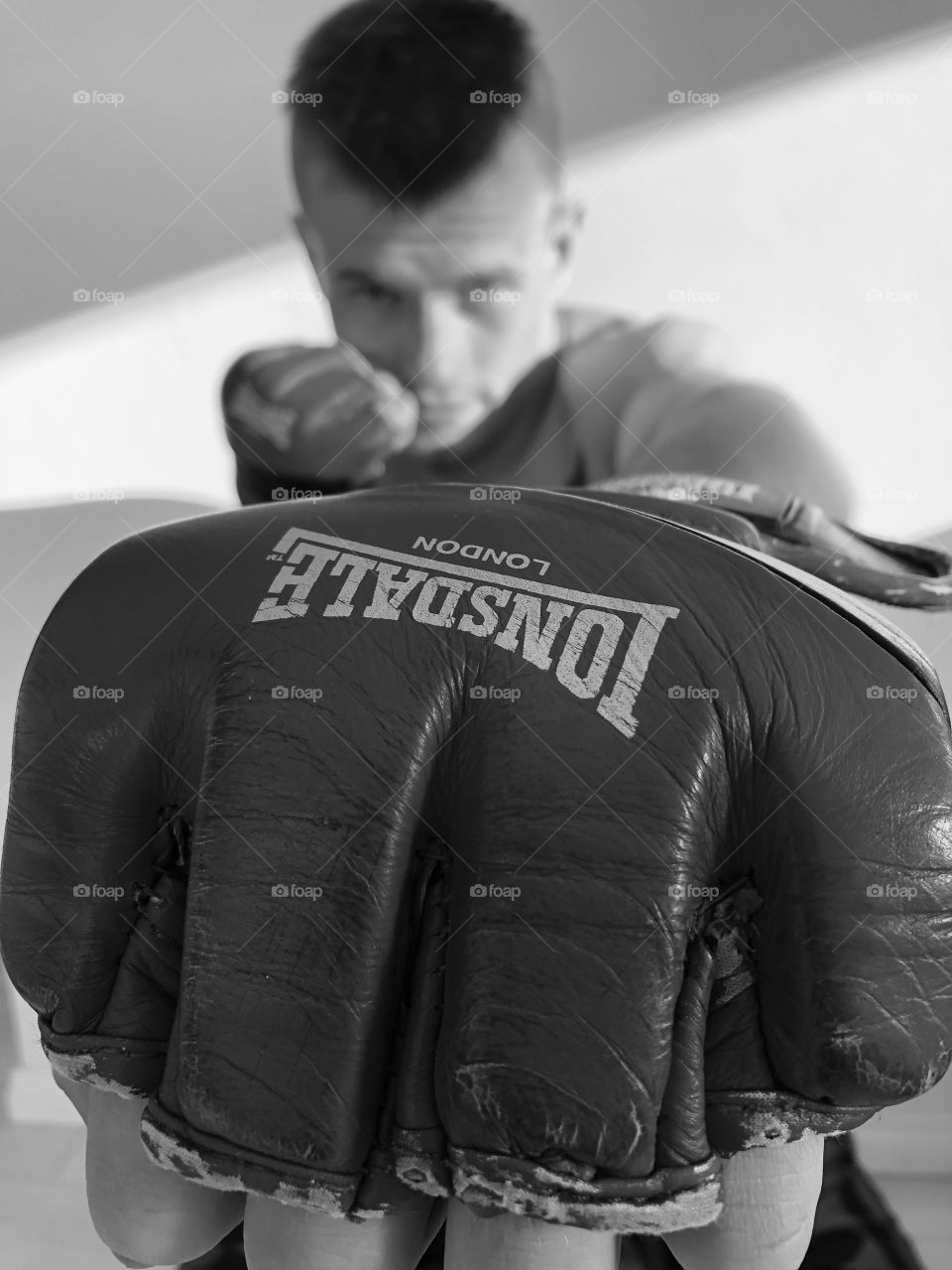 Boxing is good for your health, condition, mind and physique. Black and white picture with a boxer in the background. 