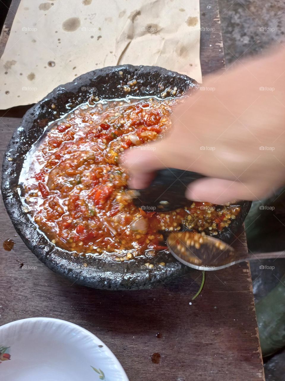 The main chili sauce is crushed so that the chili juice is released and other ingredients such as salt and shrimp paste are added