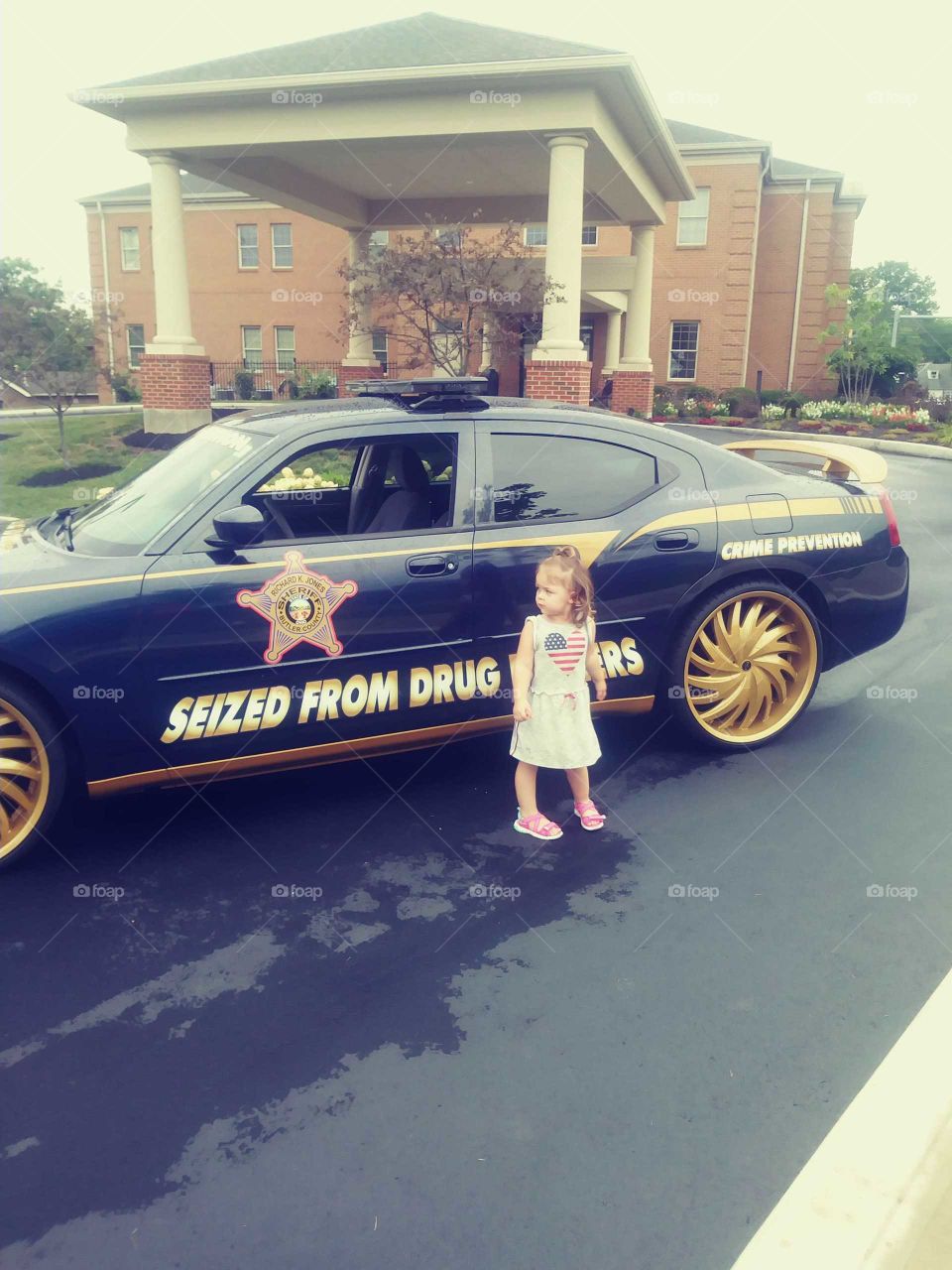 3 year old posing with a cop car