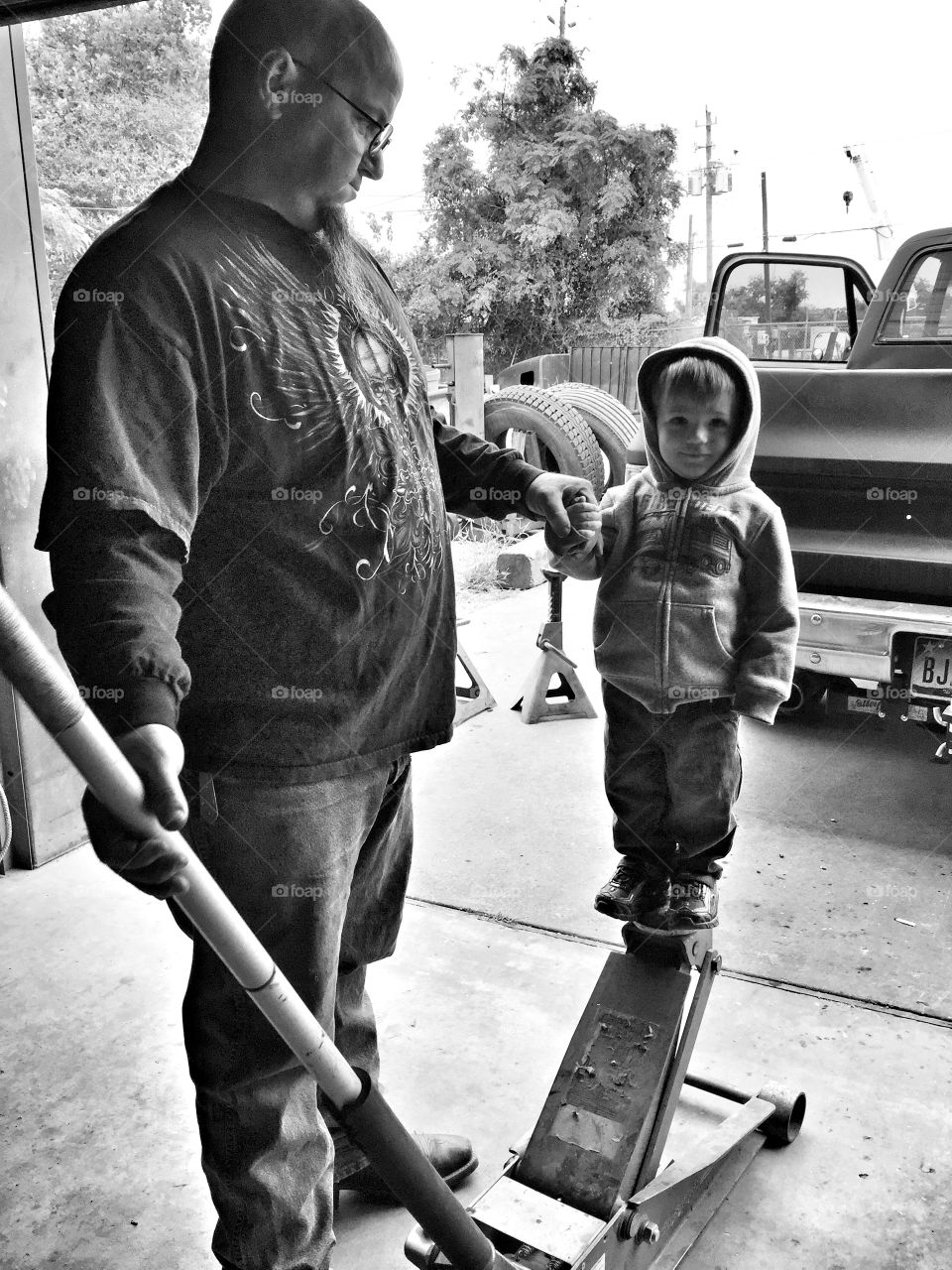 My husband jacking up our grandson on the jack. At the shop.They ere having fun