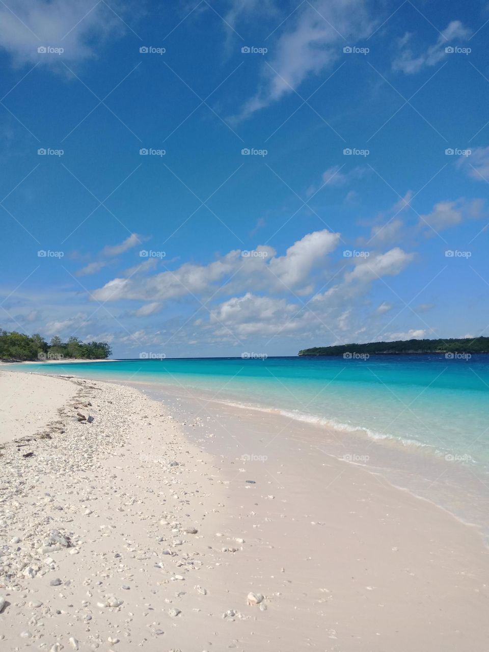 Jaco island beach,  beautiful sunny day with clear blue water,  a paradise island. White sand with shells. View of the coast and the island