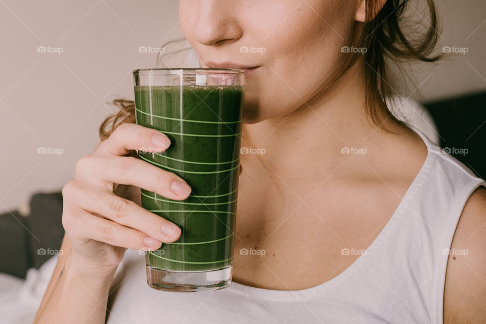 Woman drinking green smoothie, healthy diet, breakfast.