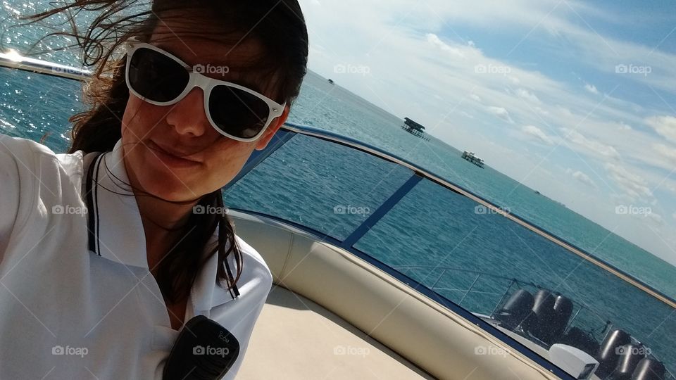 woman stewardess taking a selfie in the top of a yacht in Miami