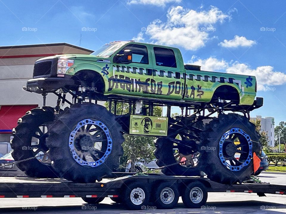 Huge bright green monster truck jacked up with large wheels