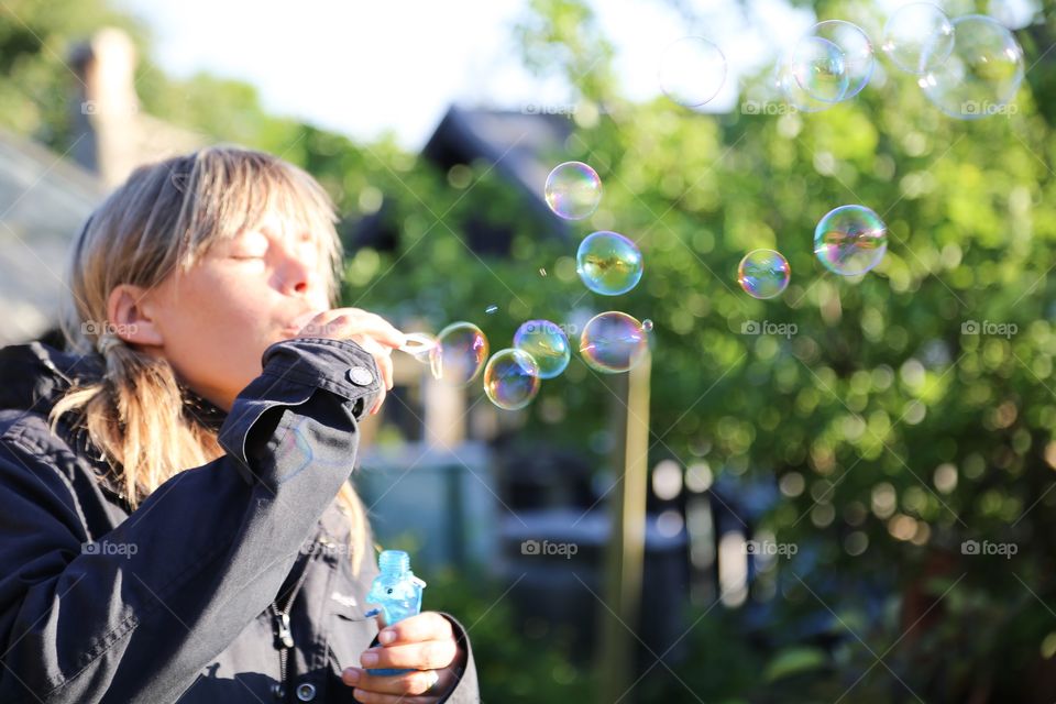 People enjoying spring . Women blowing bubbles in early spring evening 