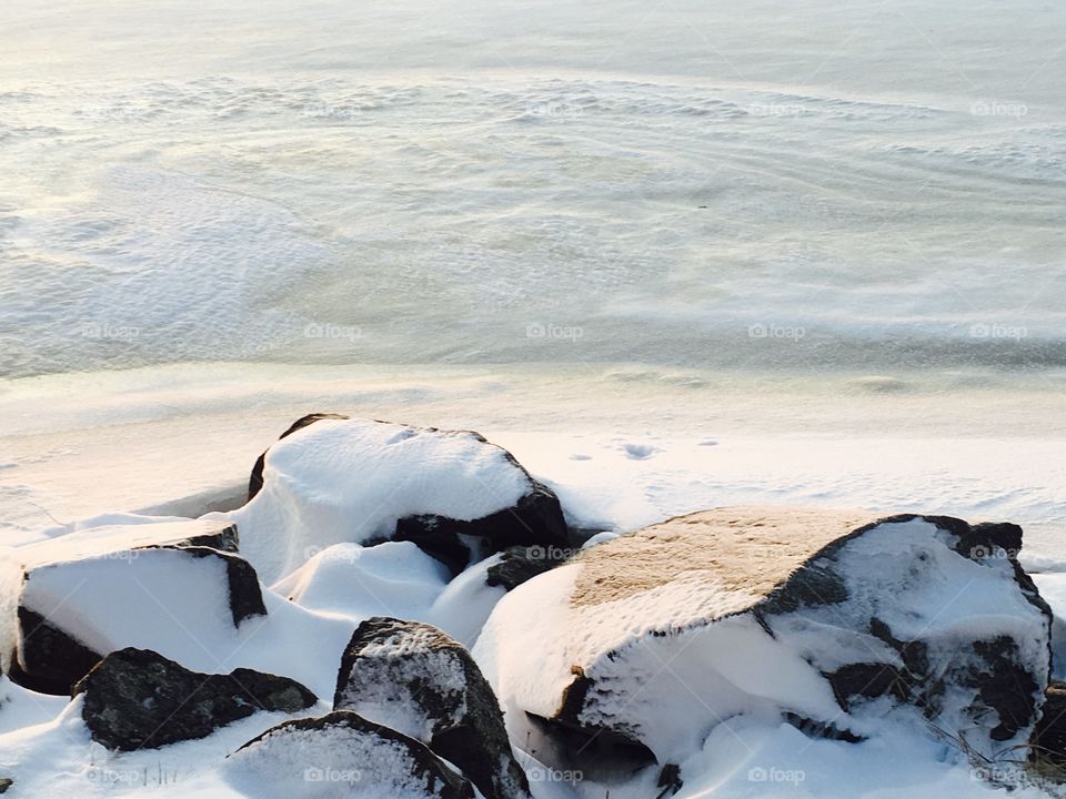 Coastline have covered with snow/ Beautiful untouched white snow on the beach stones. 