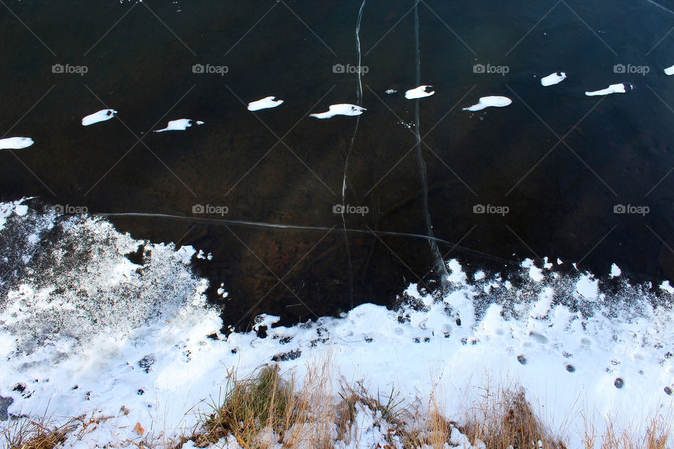 Snowy Footprints Across A Frozen Pond