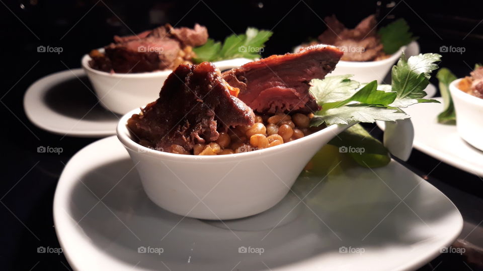 beef and lentils on a white spoon
