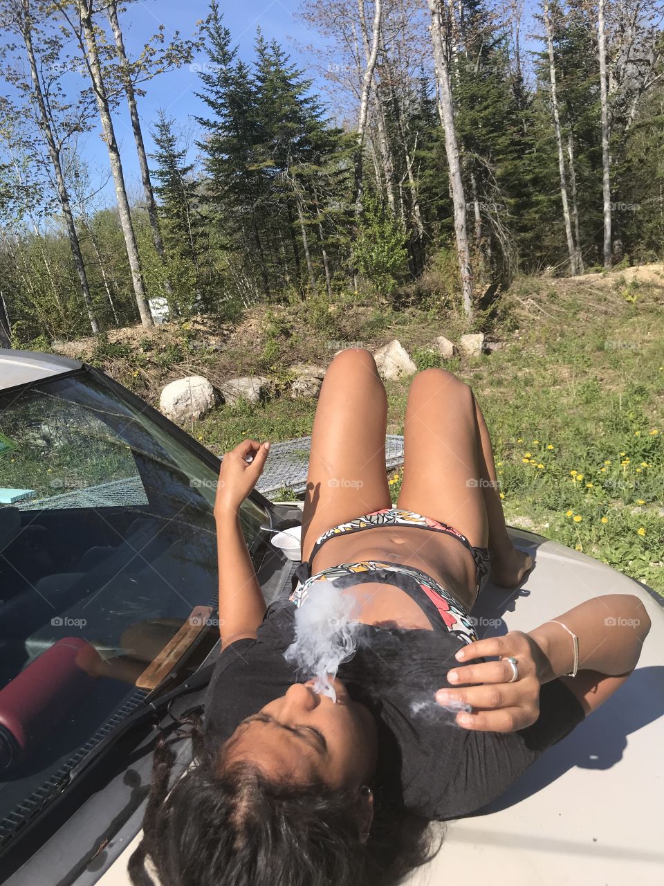 Caramel colored mamasita smoking her smoke and catching her sun on the hood of her Honda! 
