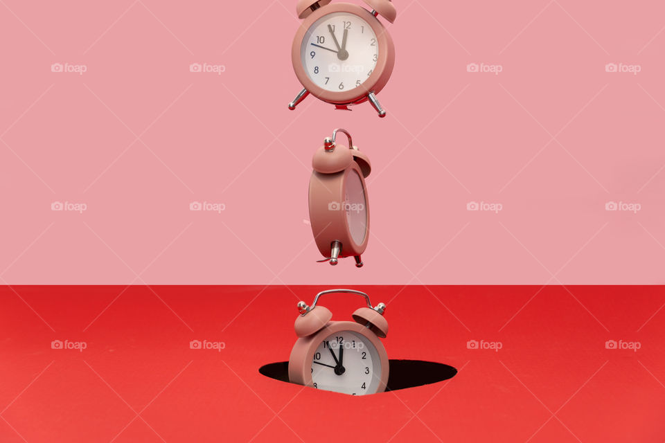 Clock falling into the hole. Creative time concept