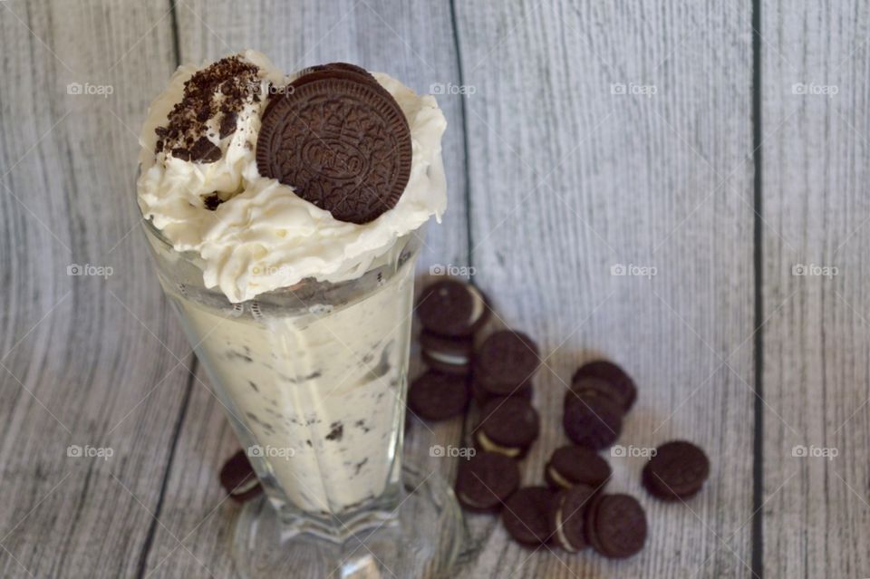 Oreo cookie milkshake with a wooden rustic white background