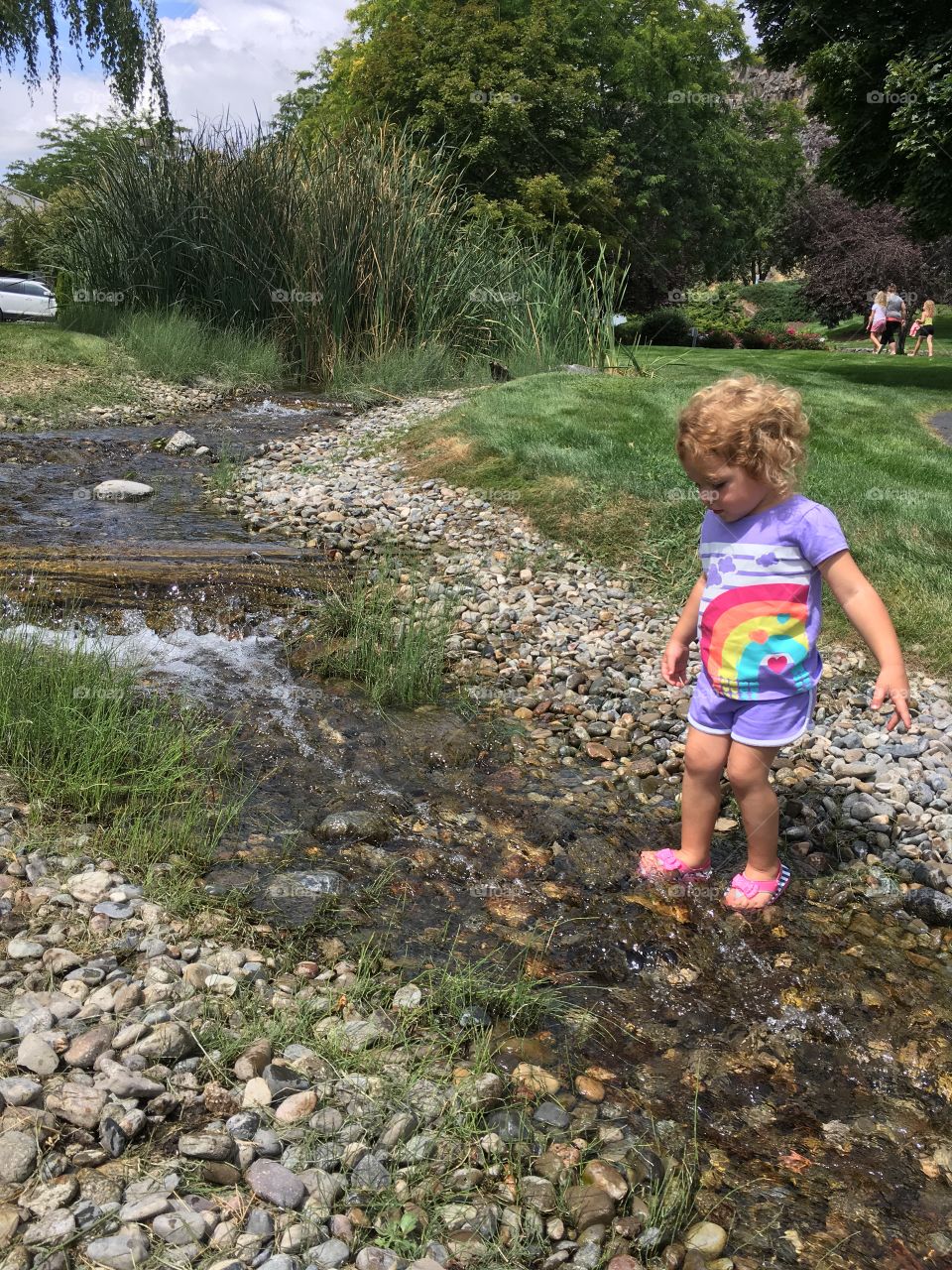 Little girl crossing a stream.