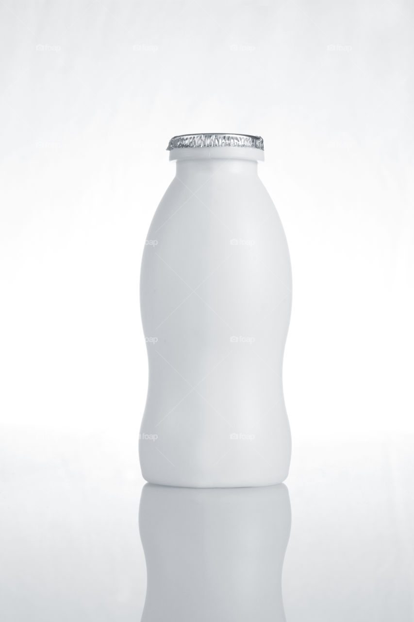 Health drink milk bottle in white background with reflection