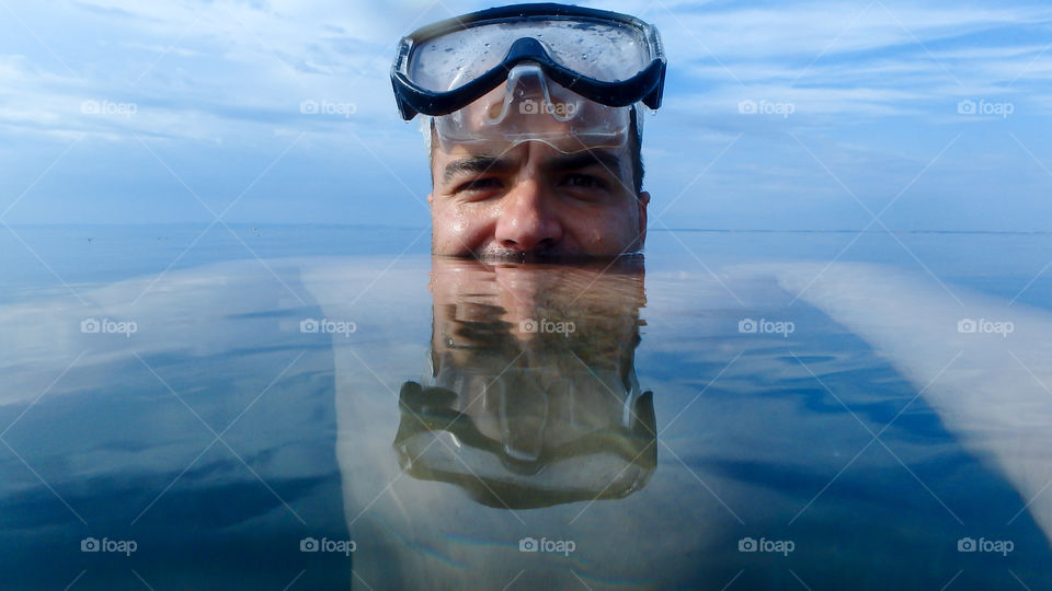 Man wearing swimming goggles in sea
