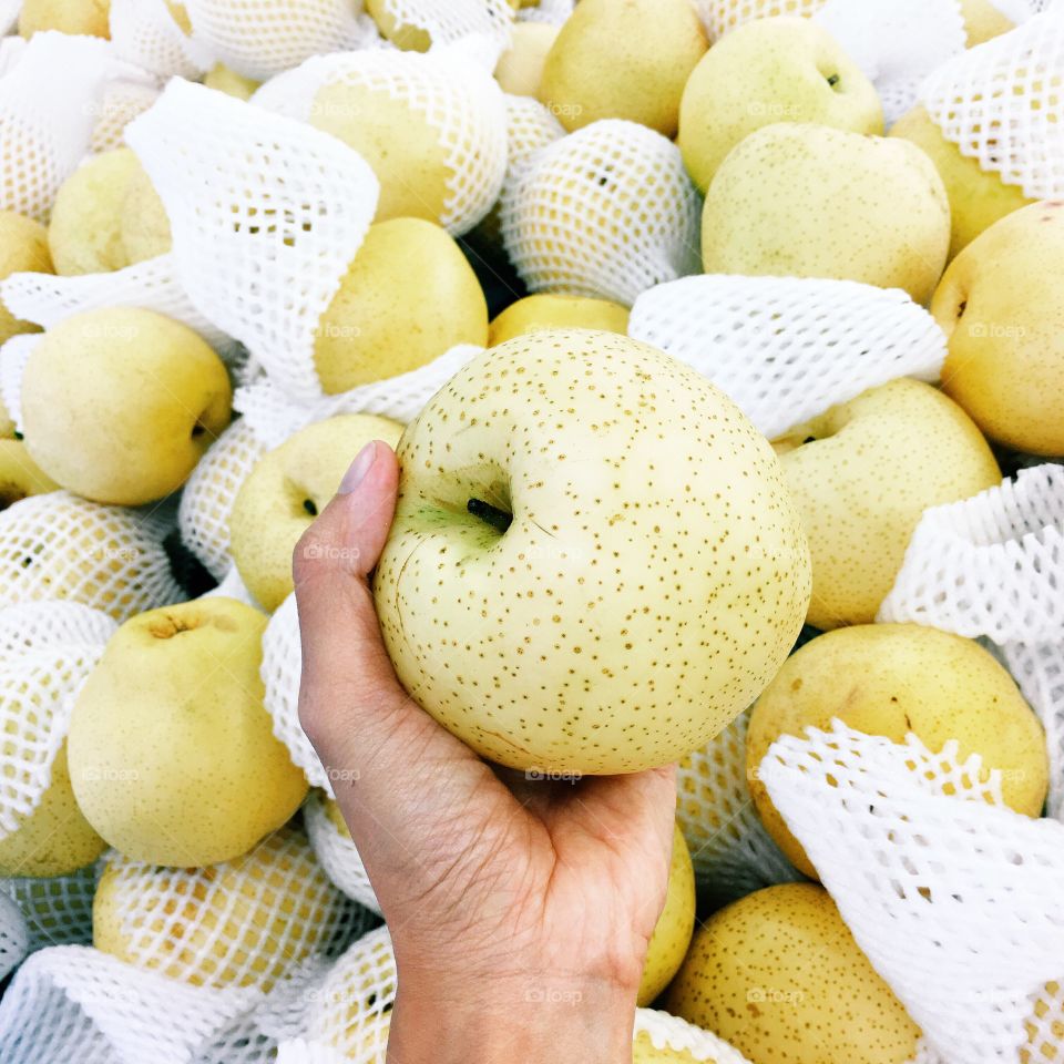 Hand holding pear in market