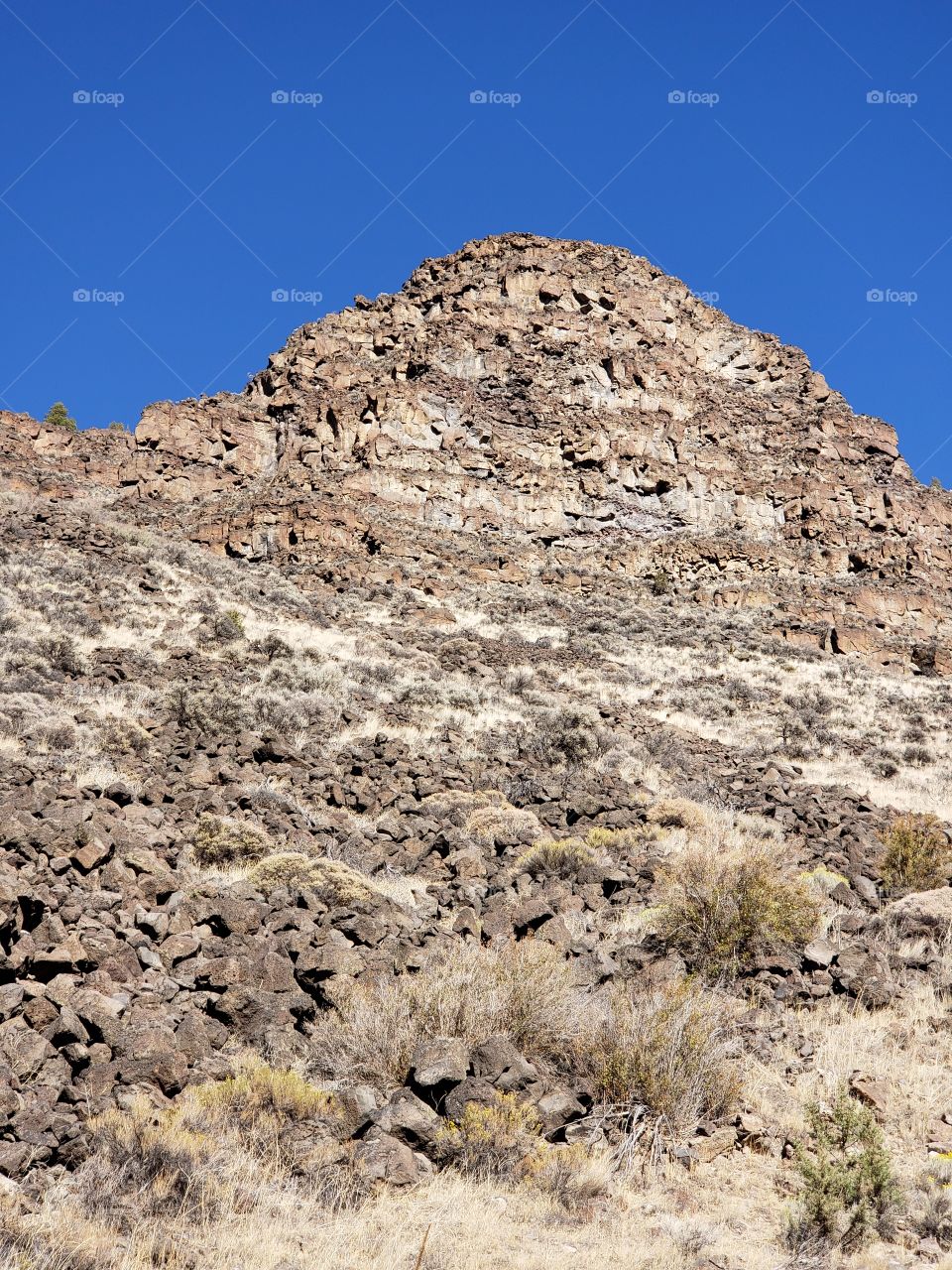 Hills along the Crooked River Highway made from andesite and basalt flows on a sunny fall day with clear blue skies in Central Oregon.