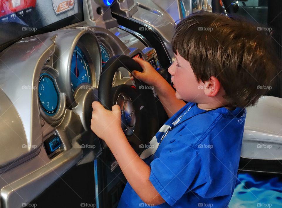 Young Video Gamer. Young Boy Playing A Race Driving Videogame
