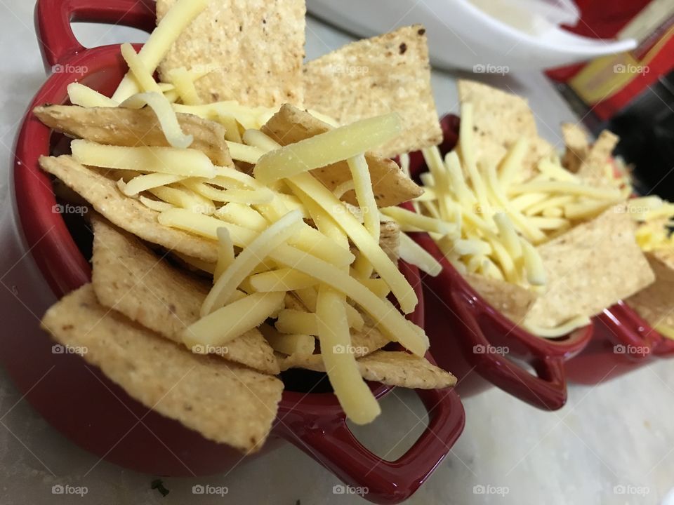 Tortilla
Chips, cheese, in small red dishes about to go into the oven and heated up and melted closeup 