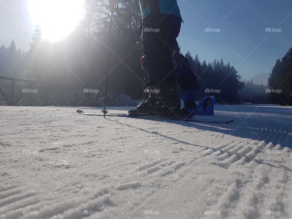 Skiing on a mountain. Bansko ski resort. Winter time, sunny weather. Skier boots and sticks