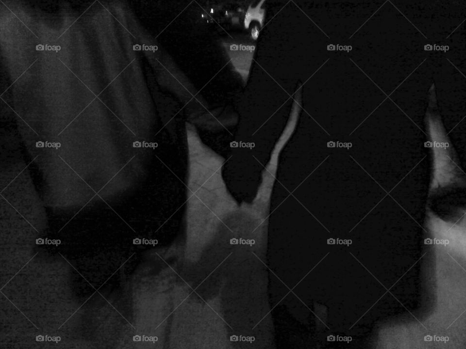 Two lovers walking at night were the source of a unique blurred lens effect. The focus of the shot is their entwined hands.