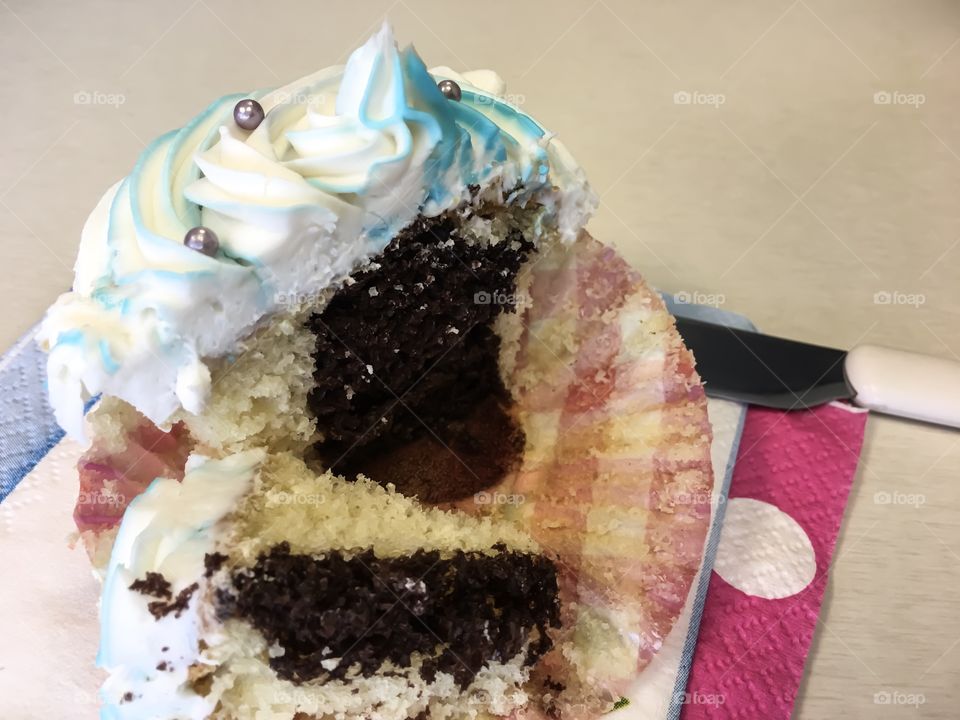 Black and white cupcake a mixed chocolate and vanilla surprise cupcake cut in half with pretty blue and white frosting swirled on top with silver sprinkles 