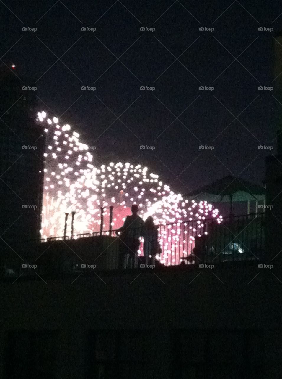 Watching fireworks from rooftp. Couple in silhouette watching fireworks from Brooklyn rooftop
