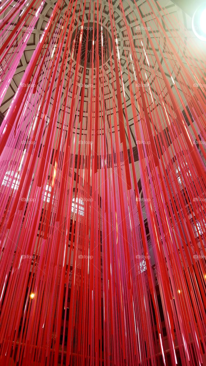Vivid pink paper streamers hanging from the museum ceiling