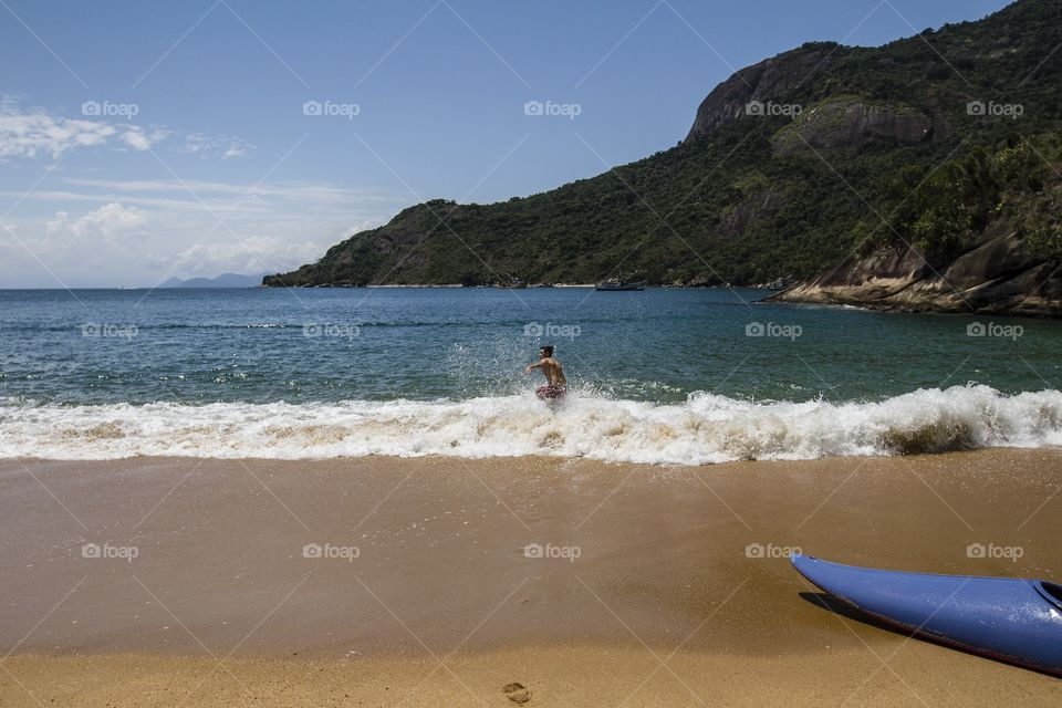 Refreshing . A man refreshing by the water at a small beach near Paraty in Rio de Janeiro 