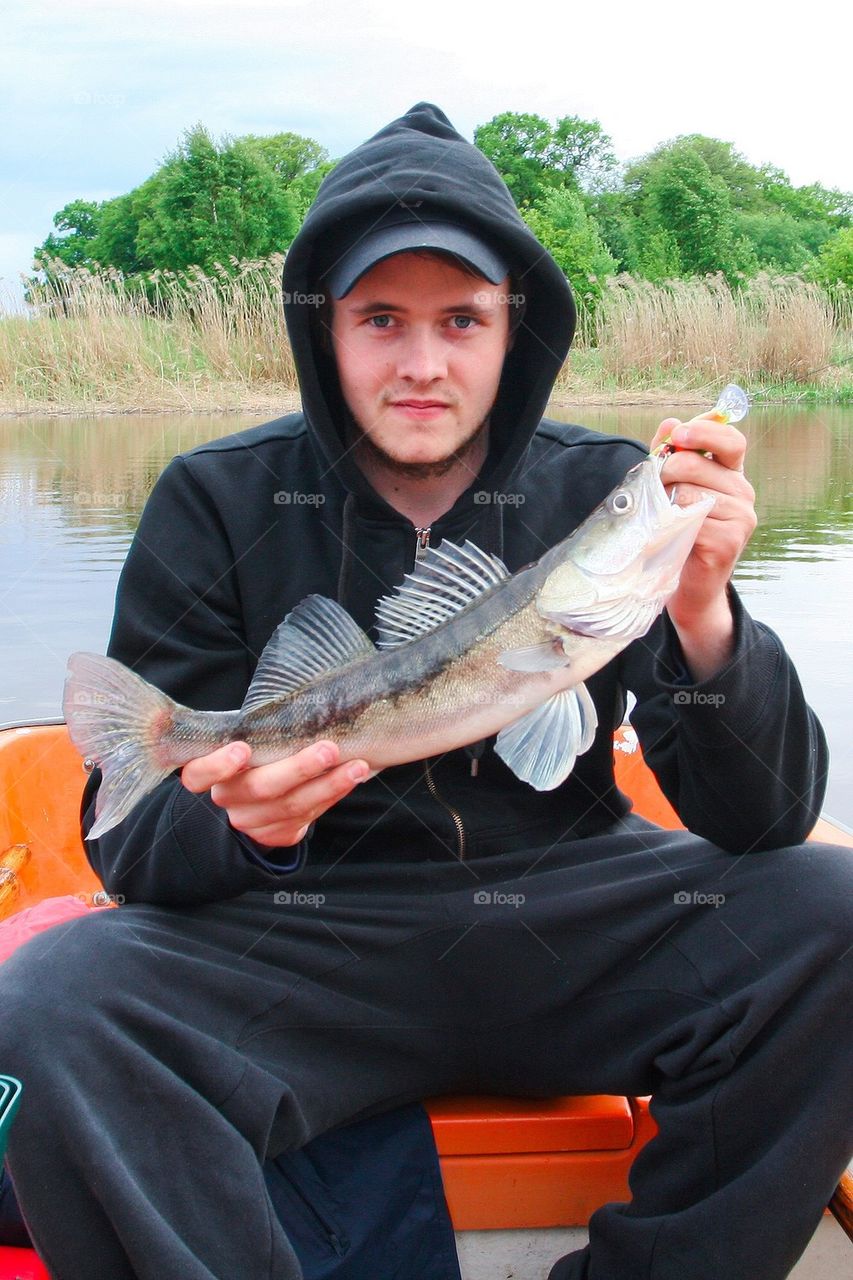 Man holding a freshly caught pikeperch