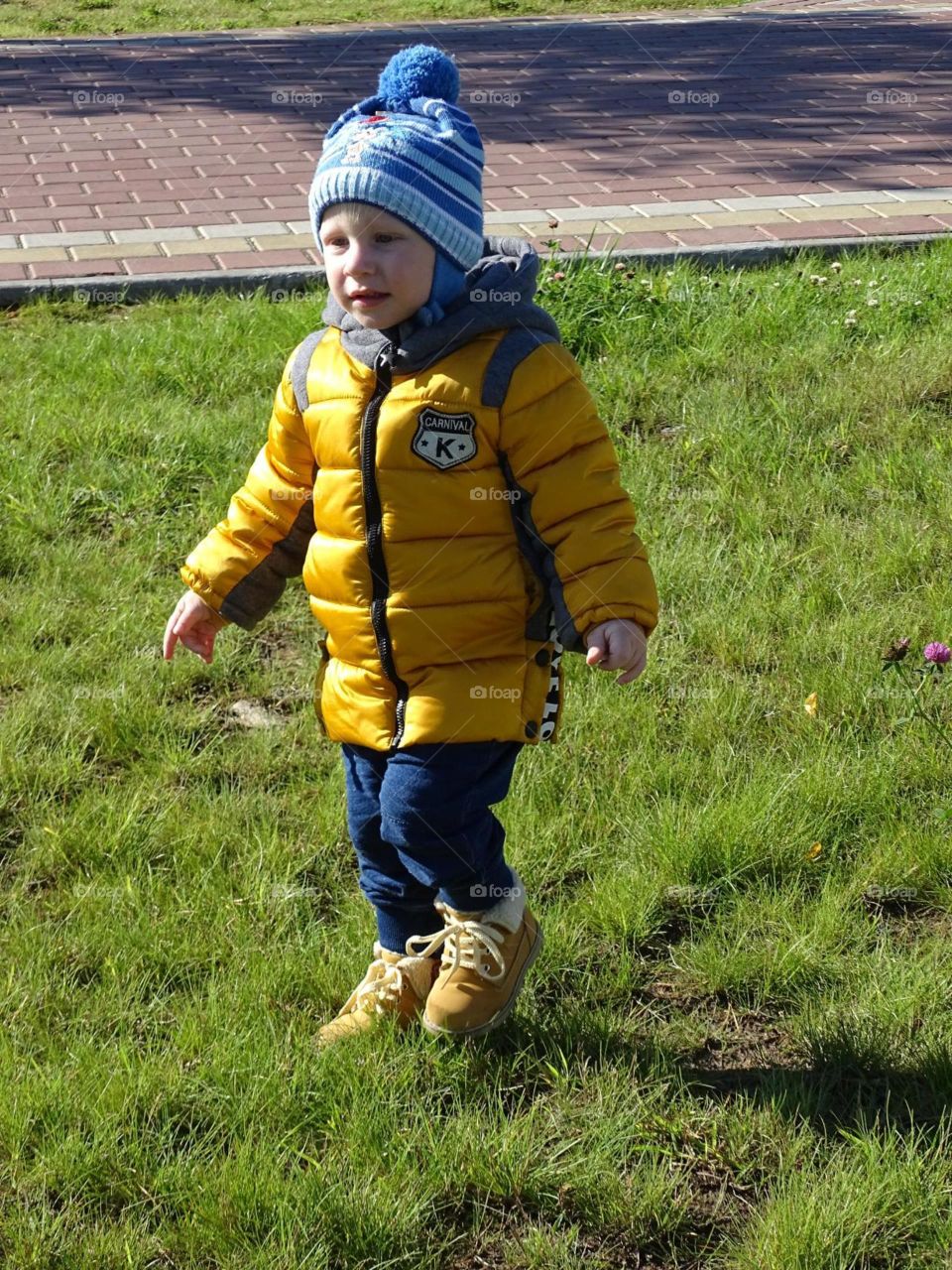 A child walks the walk day happiness joy nature outdoors run shoes boy grass green pavement autumn