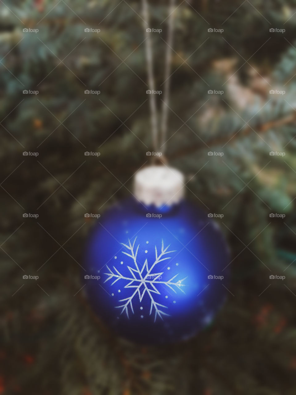 Blue ornament hanging on the Christmas tree.