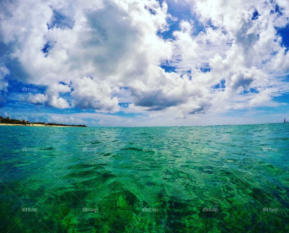 Swimming in the open water, swimming in the ocean, skies above the water, perspective of a swimmer, on vacation on an island, swimming to relax 