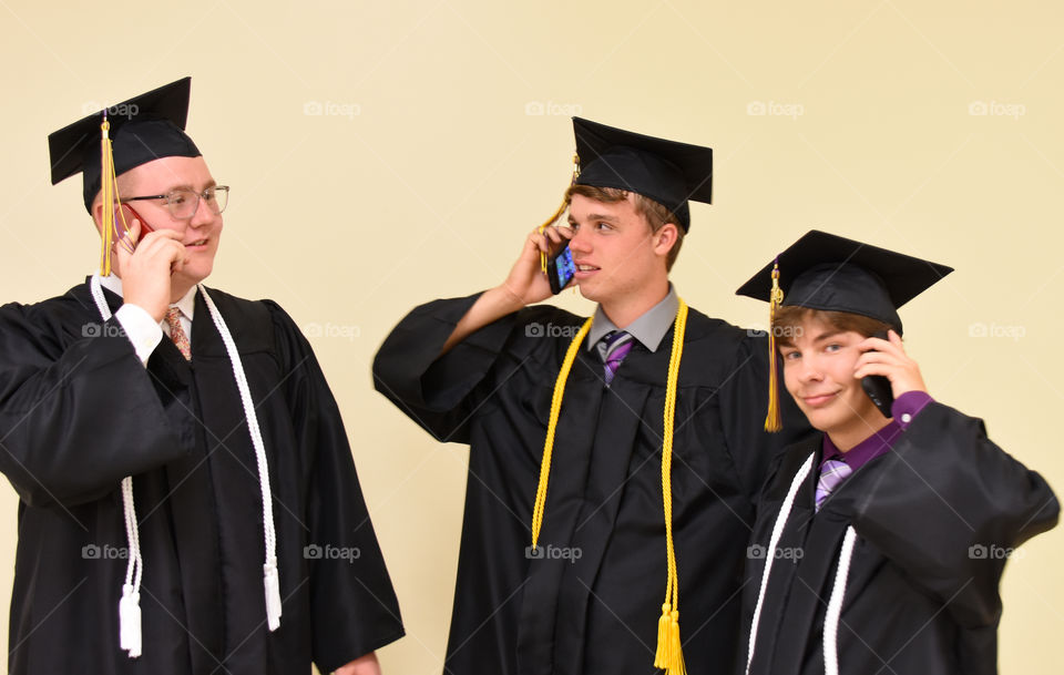 Graduates using their cell phone