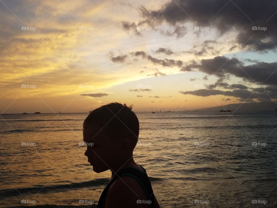 Silhouette of boy befire Waikiki sunset